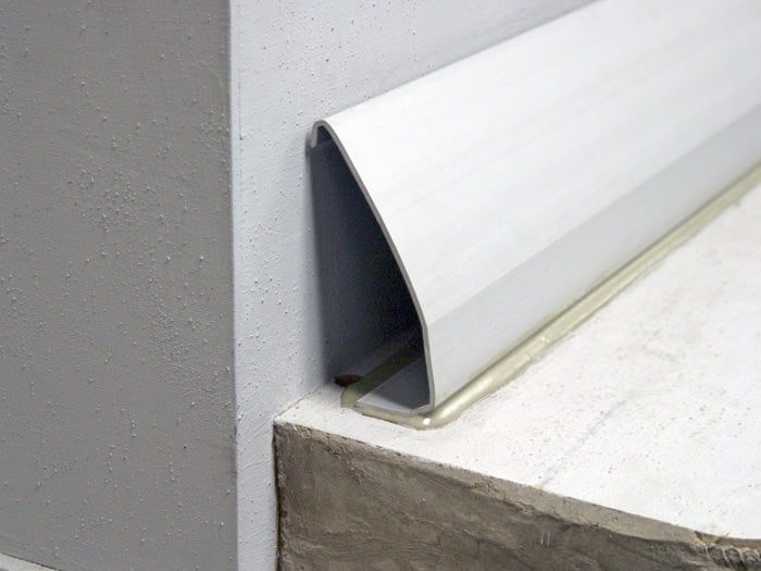 Cutaway diagram of a baseboard basement drainage system