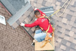 A roofing contractor fixing a roof leak in Carmel