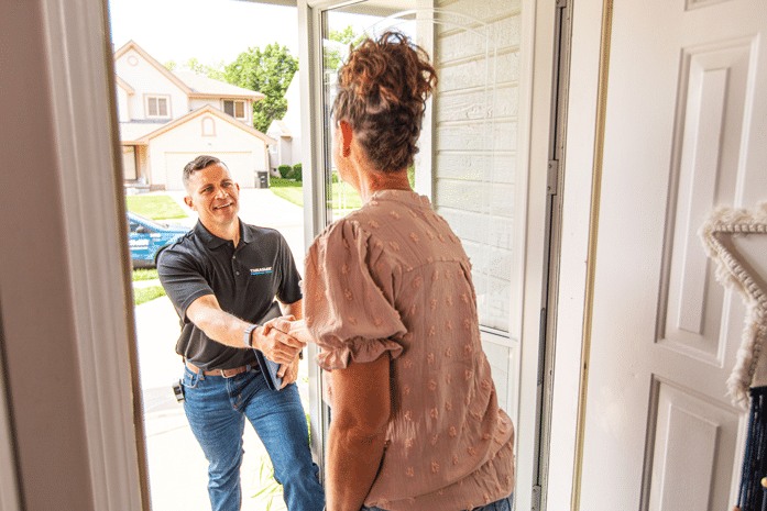 Person greeting visitor at the door of a home
