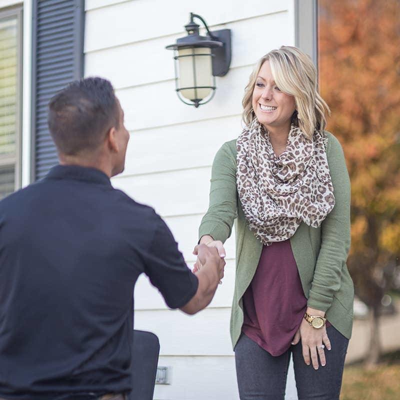Person greeting visitor at the door of a home