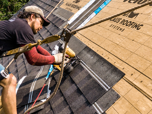 Roofer installing shingles