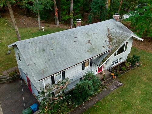 A roof with debris and damage after a storm
