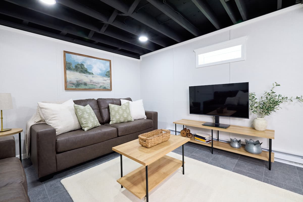 Finished basement space with waterproof wall paneling, ceiling tiles and floor system