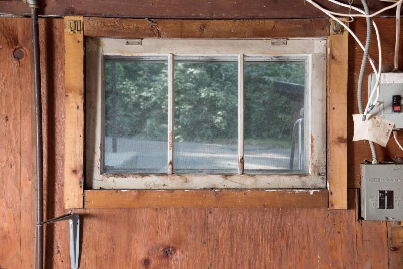 View of an old wood basement window from inside a basement