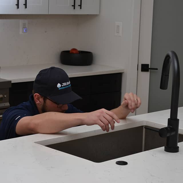 Plumber reaching into sink
