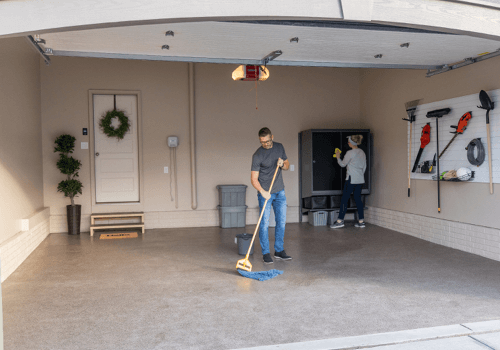 People cleaning garage floor and cabinets