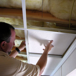 A contractor installing a suspended basement ceiling.