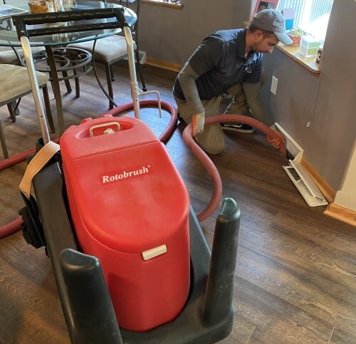 Duct cleaning contractor using a rotobrush to clean air ducts in a Des Moines home