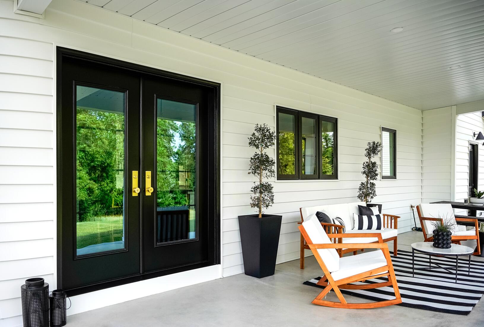 Black Legacy smooth steel French doors with full-height glass opening onto a covered patio