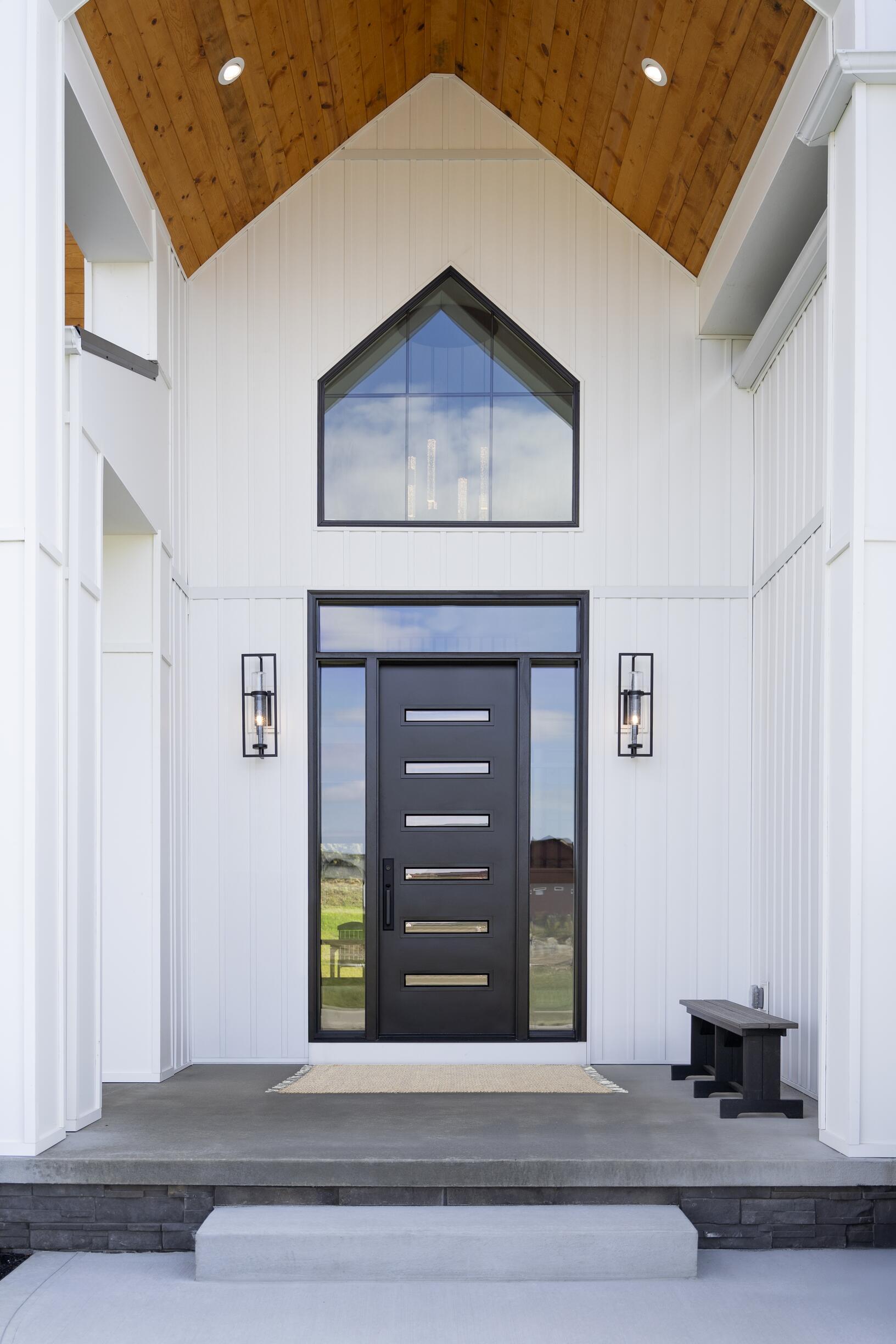 Open coal black entry door showing horizontal glass inserts, sidelites and an overhead transom