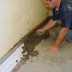 Restoring the concrete floor after a basement drain system is installed.