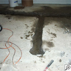 A lateral drain installation in progress in a wet basement.