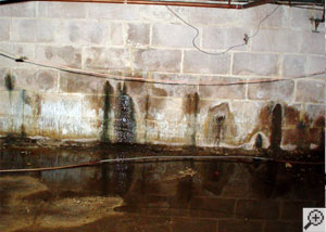 Water seeping through the concrete of a block wall