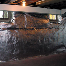 A reflective radiant heat barrier installed on a basement wall