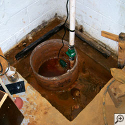 A large sump pit installed in a basement floor.