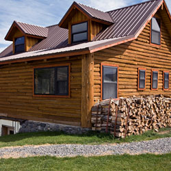 A house with wood piled along the side.