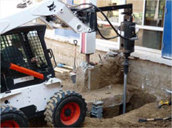 Advancing helical piers adjacent to existing column footings