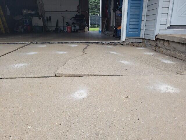 Severely Cracked and Sunken Concrete Driveway Repaired & Sealed in Green Bay, WI - Before Photo