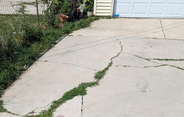 Severely Cracked Concrete Driveway Stabilized & Repaired in Sheboygan, WI - Before Photo