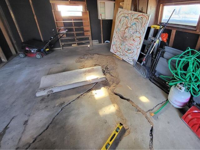 Severely Cracked and Uneven Concrete Garage Floor Repaired and Sealed in Menasha, WI - Before Photo
