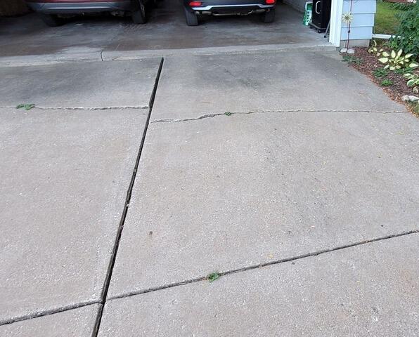 Cracked and Sunken Concrete Driveway Repaired in Oshkosh, WI - Before Photo