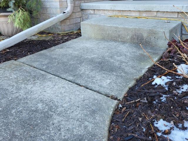 Sinking Concrete Driveway Lifted, Repaired & Sealed in Sturgeon Bay, WI - Before Photo