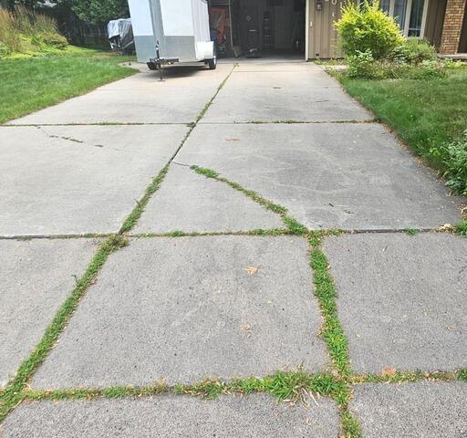 Sinking Concrete Driveway Slabs Lifted & Repaired, Fixing Trip Hazards & Water Issues in Rothschild, WI - Before Photo
