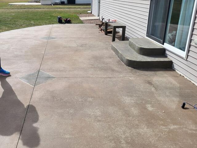 Decorative Stamped Concrete Patio Lifted, Repaired & Sealed in De Pere, WI - Before Photo
