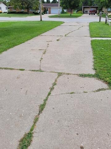 Cracked and Uneven Driveway and Sidewalk Repaired in Pulaski, WI - Before Photo