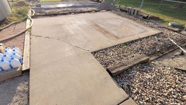 Concrete Leveling and Crack Sealing for Backyard Slab and Garage Walkway in Black Creek, WI - Before Photo