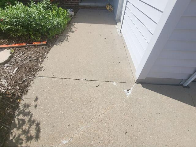 Concrete Driveway and Front Sidewalk Leveling and Crack Repair in Combined Locks, WI - Before Photo