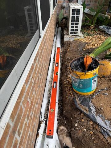 Exterior Drainage Installation for Enclosed Patio Water Intrusion in Jacksonville, FL - Before Photo