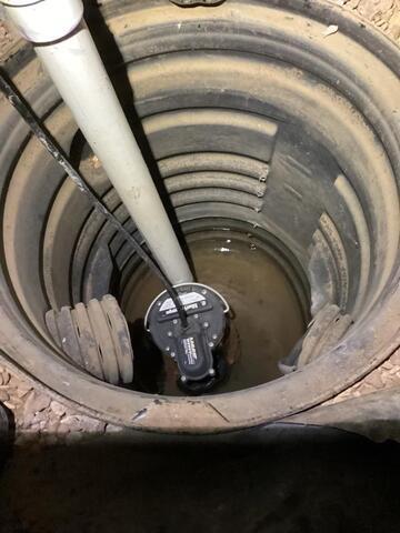 Sump pump with water sitting at the bottom. 