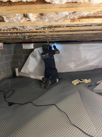 Frontier technician installing CleanSpace to crawl space wall.