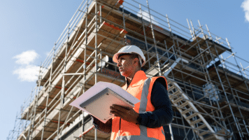 Man standing under a building in construction.