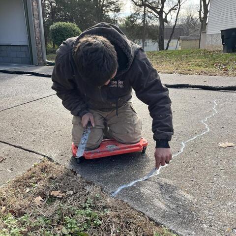 Frontier crew member sealing concrete cracks. 