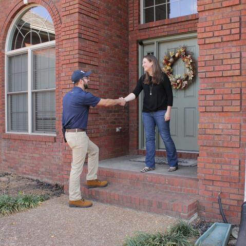 Design Specialist greeting a customer at their home.