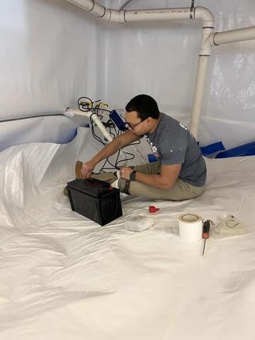 Frontier crew member installing TripleSafe sump pump.