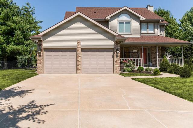 Concrete driveway after photo leveled and repaired in front of brown home