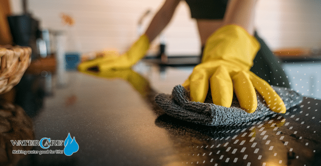 Gloved hand cleaning countertop