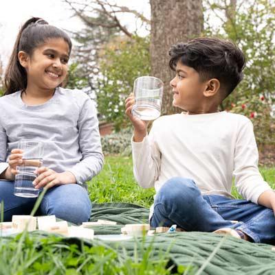 kids drinking water from glass outside