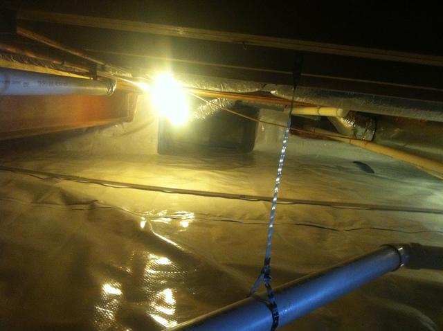 As the CleanSpace is installed, a heavy duty tape is used to secure all seams to insure that no water can seep through the liner.  In this picture, you can see the seams are in the process of being secured.  You can already see a tremendous difference between the original crawlspace and new reflective white surface of the Cleanspace