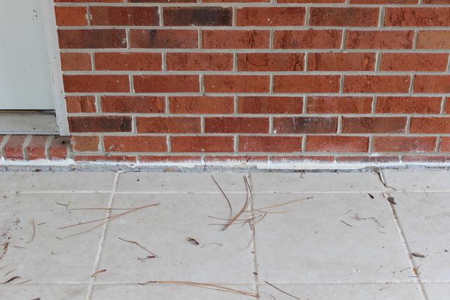 Before- sinking slab porch, approximate 2" settlement causing gap and cracking of tile