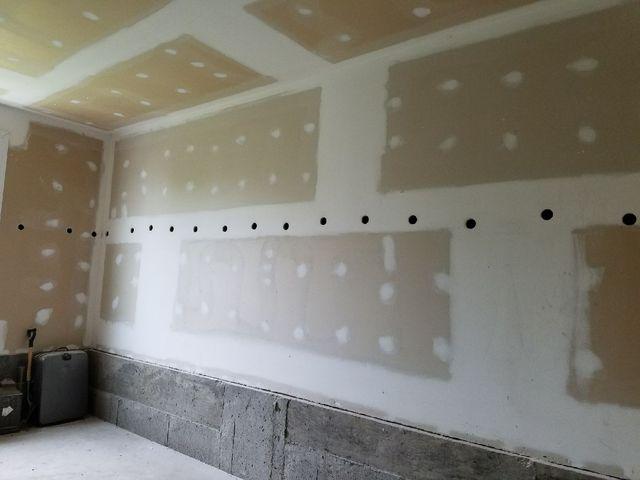 A series of holes are made in each of the vertical wall stud cavities. This allows us to install the cellulose dense packing hose into the wall.