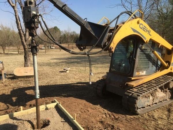 Skid Steer Driving a helical pier