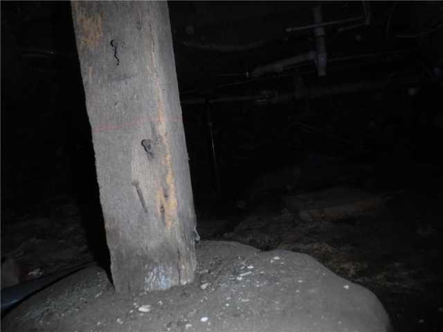 The former crawl space support posts were just wooden posts balanced on concrete. This isn't sustainable long-term, especially in a damp environment, because water will cause the posts to break down and lead to failing joists.