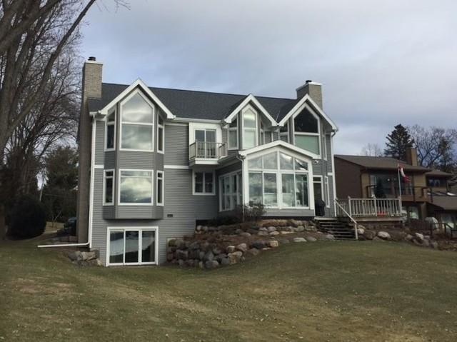 After Photo: This home now has a new roof, siding, and gutters. The darker colored roof and siding make the white trim pop!