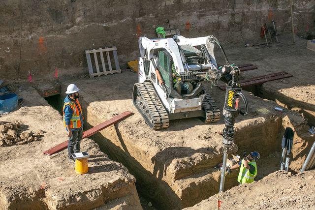 Exterior photo of construction site driving piers into foundation area