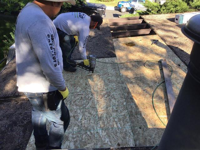 Removing tar and gravel and rotten decking, sheet by sheet, and installing new decking.