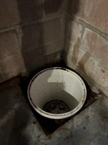 Progress image showing the excavated area for the sump pump basin.